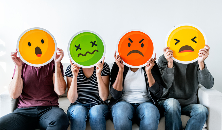 people holding emoji masks