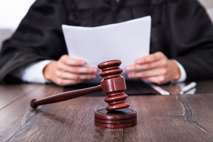 gavel positioned in front of judge holding papers