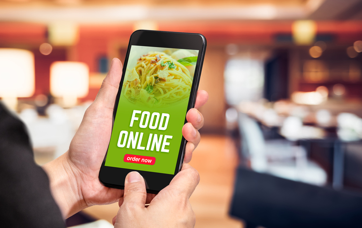 Close up hand holding mobile phone with order food online word on screen