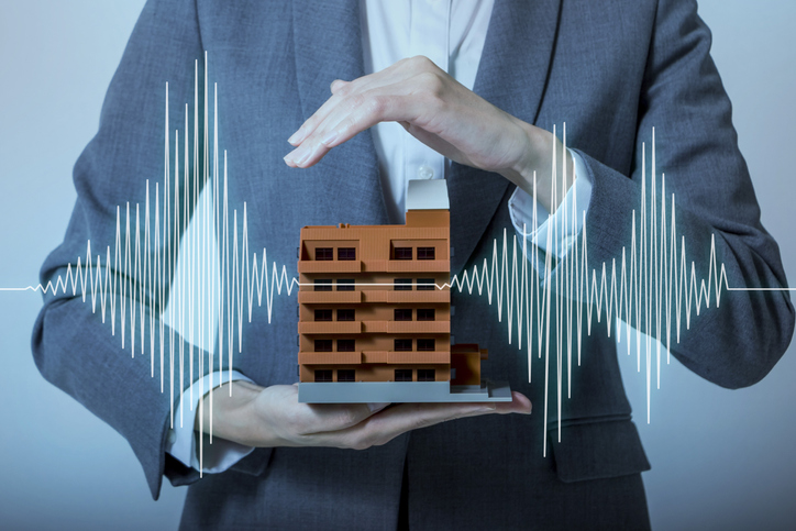 businessman holding building between hands