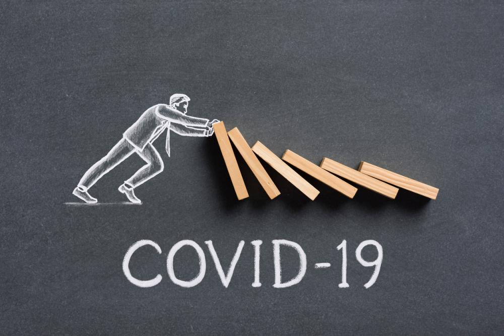 covid-19: businessman stops toppling dominoes