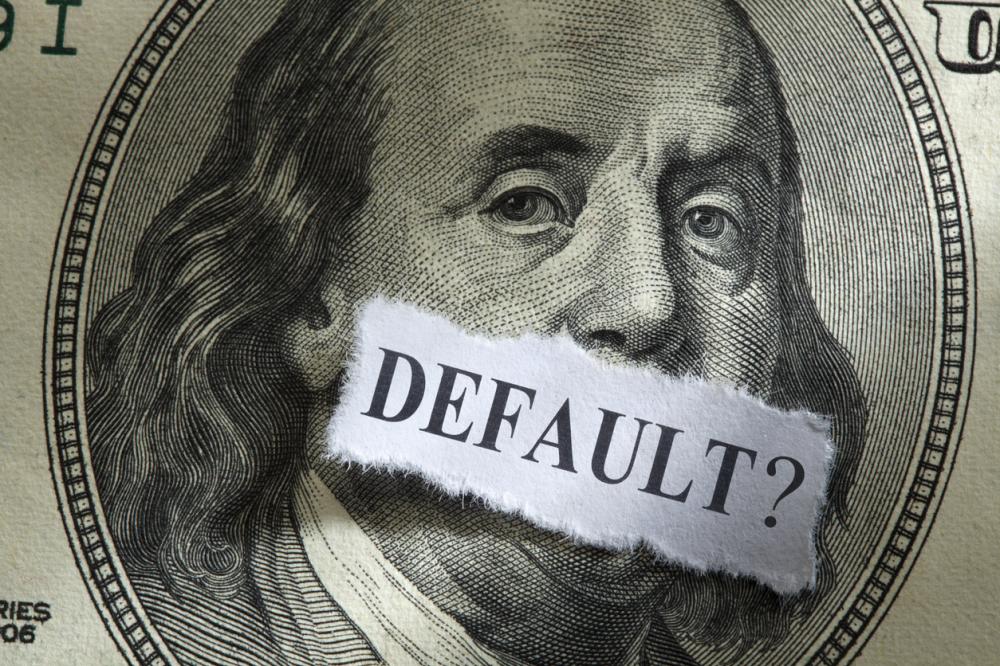 Debt concept: default written on paper and pasted on one hundred dollar bill