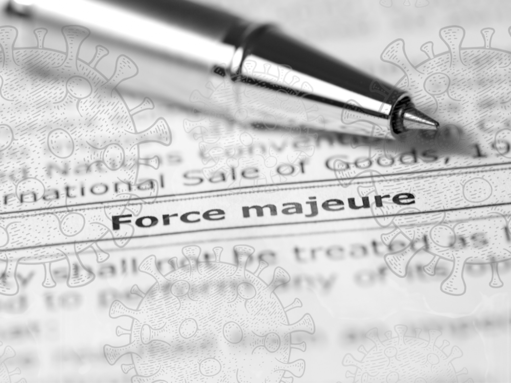 paper that reads "force majeure" with a pen nearby and semi-transparent covid-19 bacteria floating around
