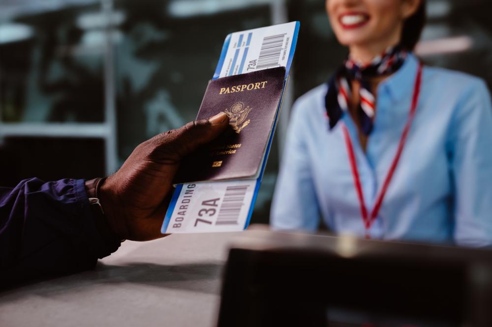 man holding passport and boarding pass at airline check in