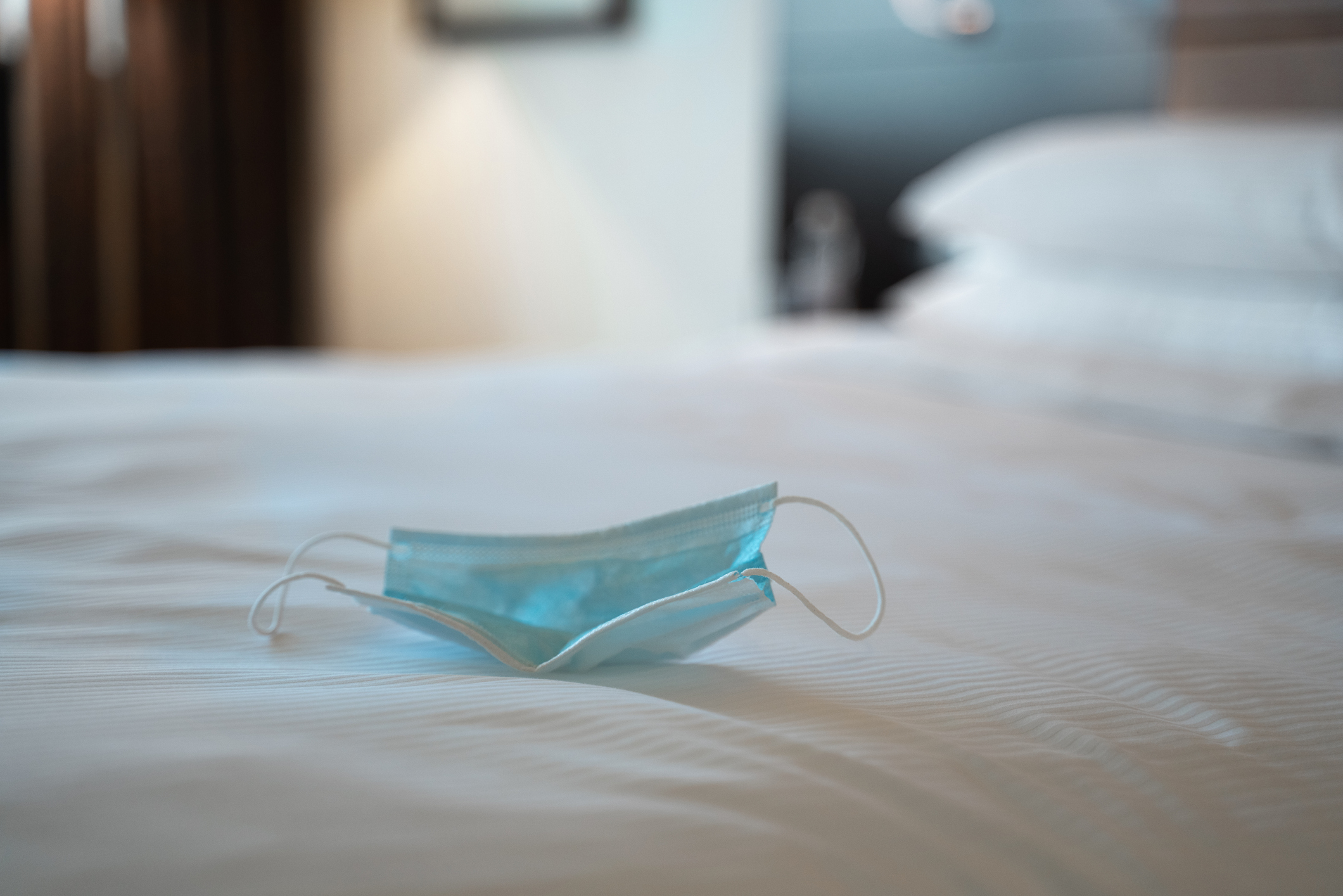 medical face mask on hotel bed