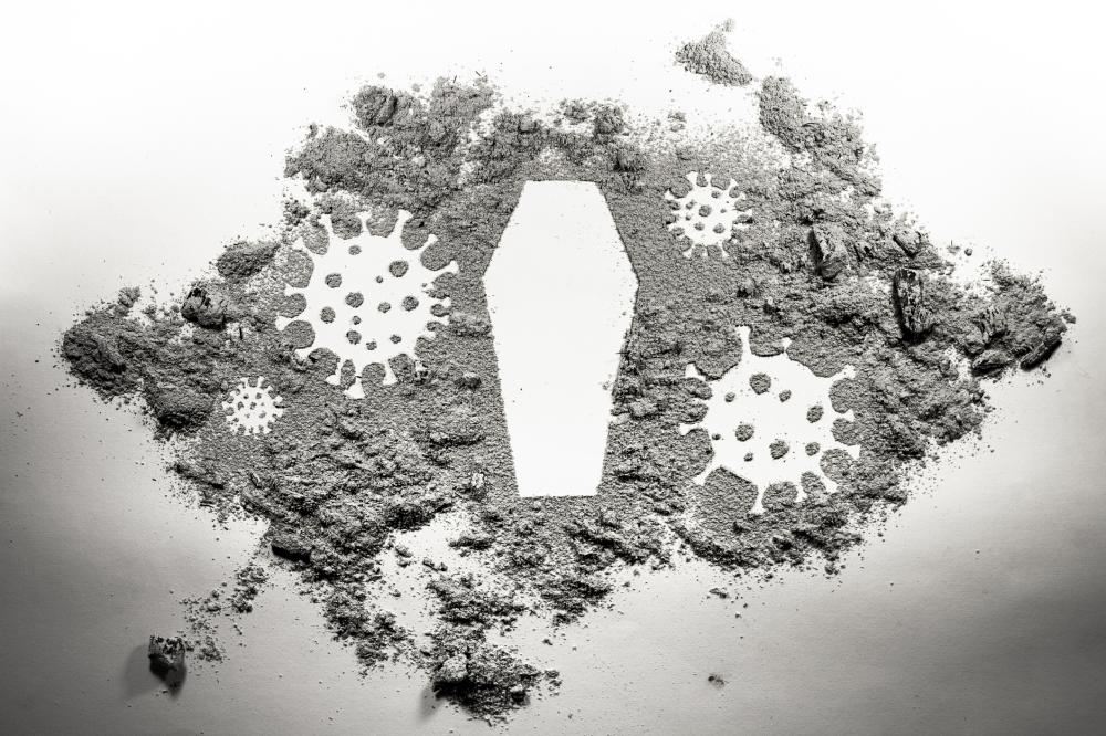 covid-19 germs and coffin outlined in ashes