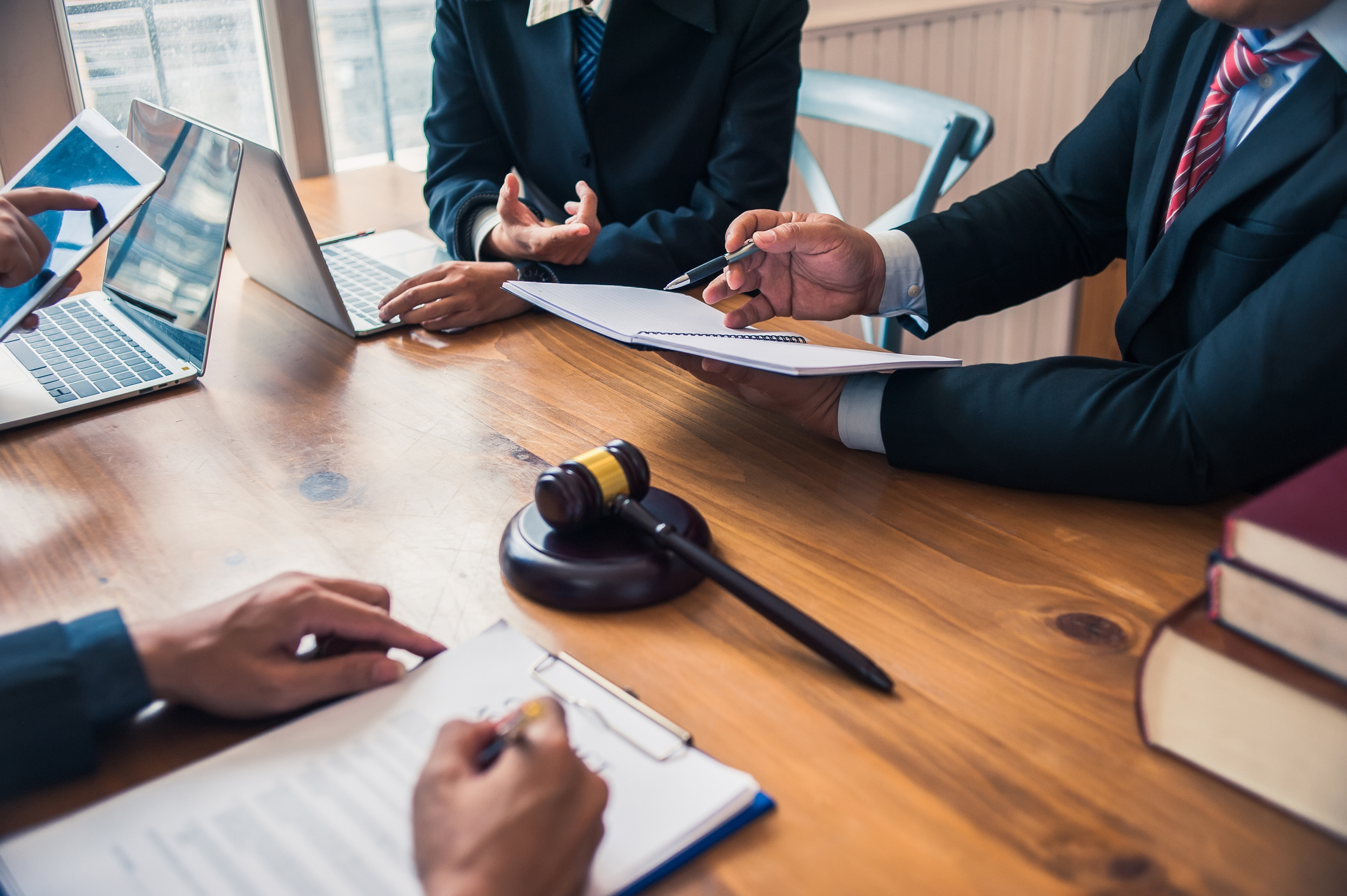 four people in suits gathered for arbitration meeting