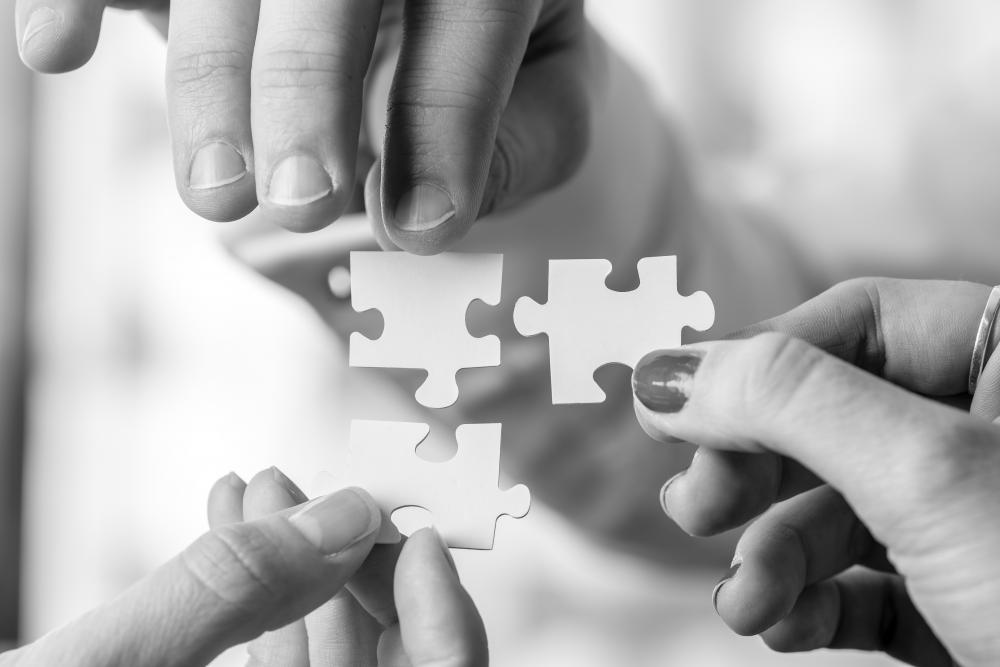 three people connecting three puzzle pieces