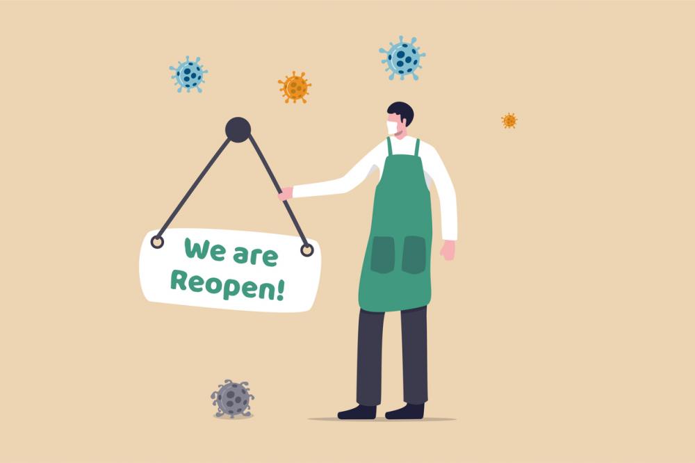 employee with "we are reopen" sign